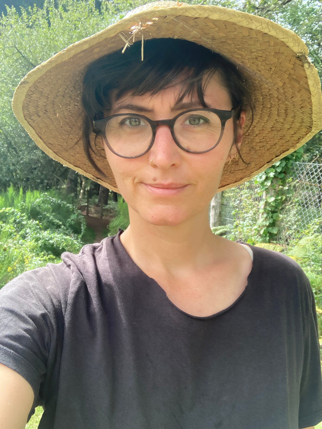 Pauline Pillot au jardin avec un chapeau de paille sur la tête