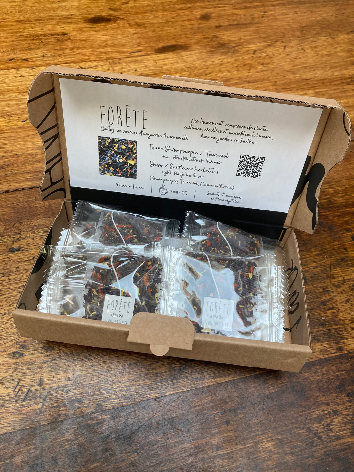 une boîte d'infusettes avec un texte de présentation à l'intérieur et 10 infusettes individuelles.